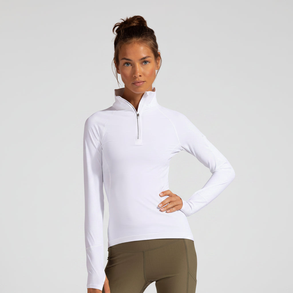A woman wearing a white long sleeve sun protective 3/4 zip top with thumb holes and a functional pocket on the sleeves.