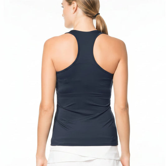 Back view of woman wearing a navy racer back tank top and white skirt on a white background