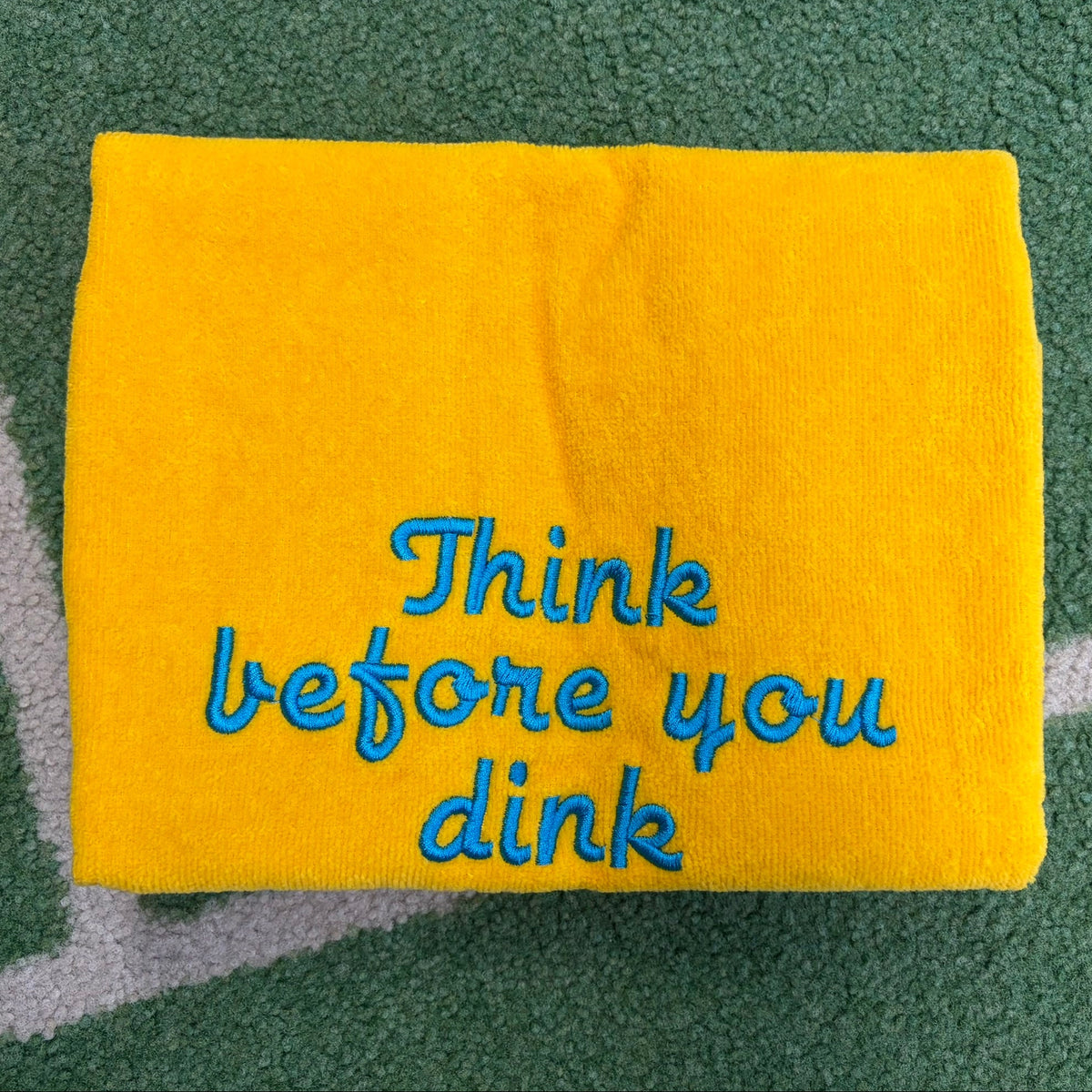 Yellow towel embroidered with blue Think Before You Dink lettering