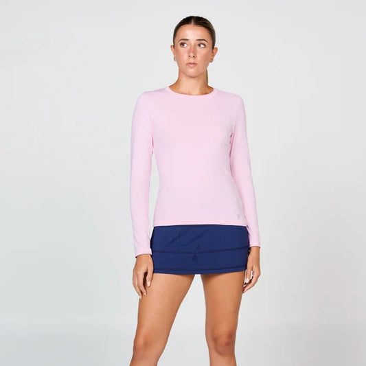 Woman wearing a pink long-sleeve top and blue skirt on a white background
