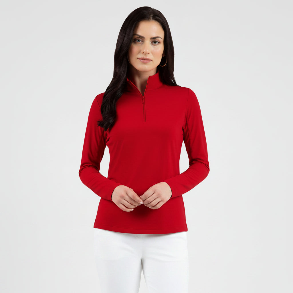 Woman wearing a red long-sleeve mock zip top with white pants background