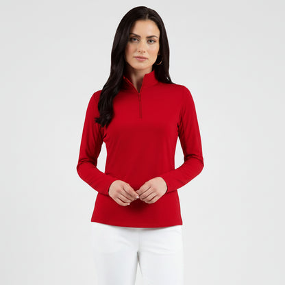 Woman wearing a red long-sleeve mock zip top with white pants background