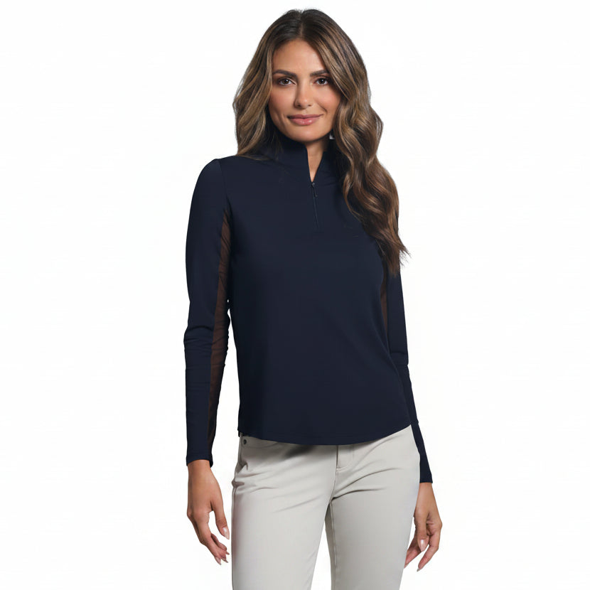 Woman wearing a classic black long-sleeve mock zip top and light-colored pants on a gray background