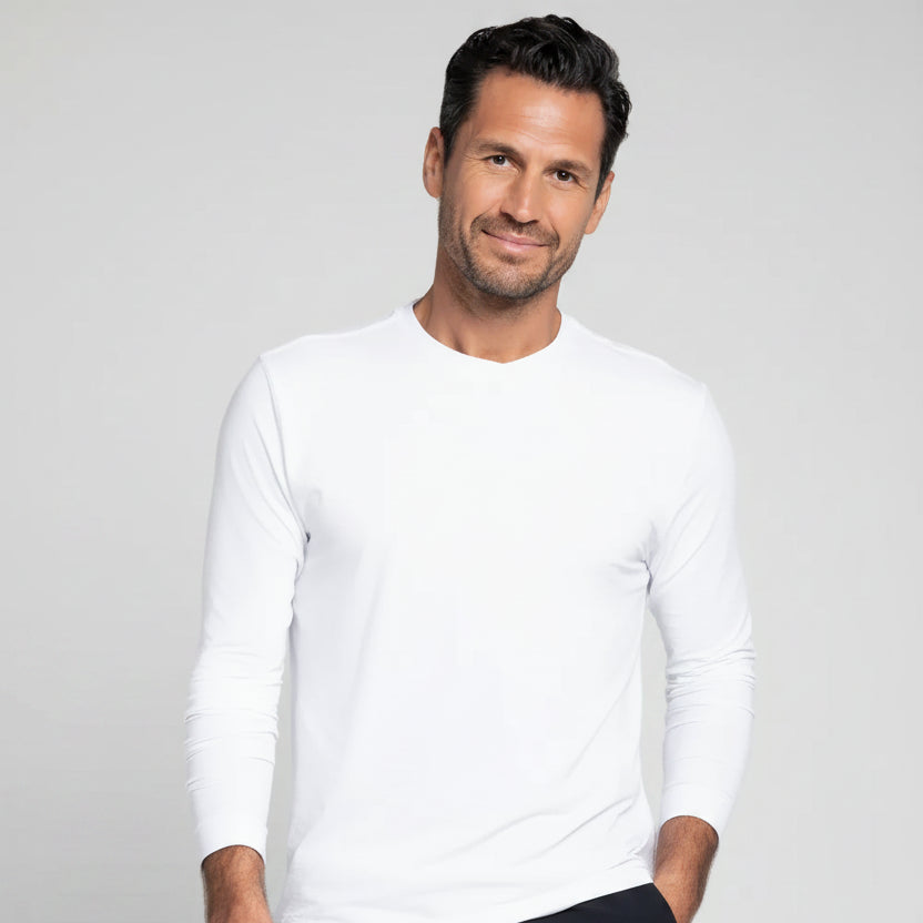 Man wearing a white long-sleeve shirt and black shorts on a gray background