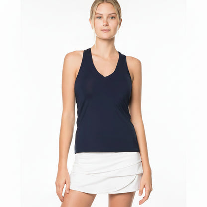 Front view of a woman wearing a navy v neck tank top and white skirt on a white background