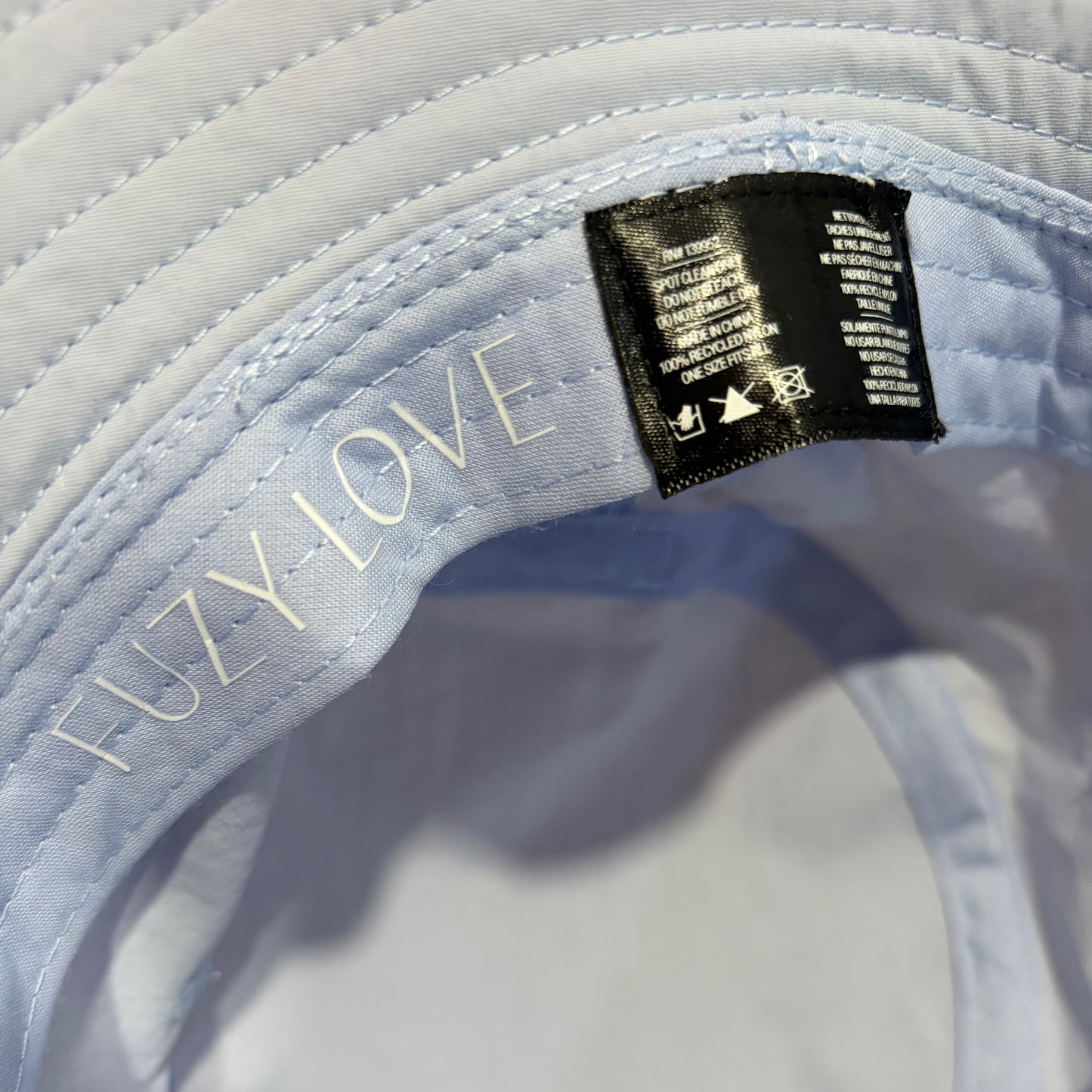 Close-up of the interior materials label of a powder blue bucket hat.