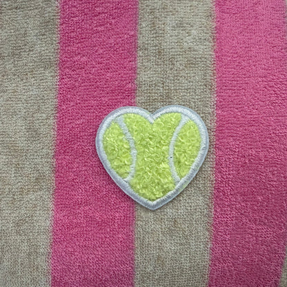 Striped towel with a heart-shaped green patch on a pink and gray background