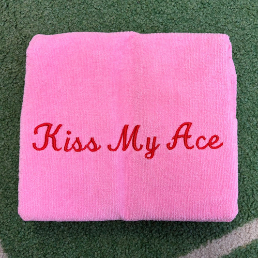 Light pink towel embroidered with red Kiss My Ace lettering