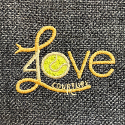 Close-up of the 40 Love Courture logo embroidered on the bag's woven-look fabric