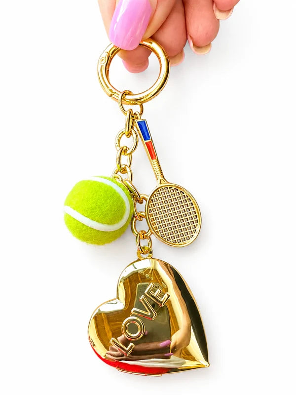 Fuzy Love LOVE heart locket keychain with tennis ball and racquet charms on white background